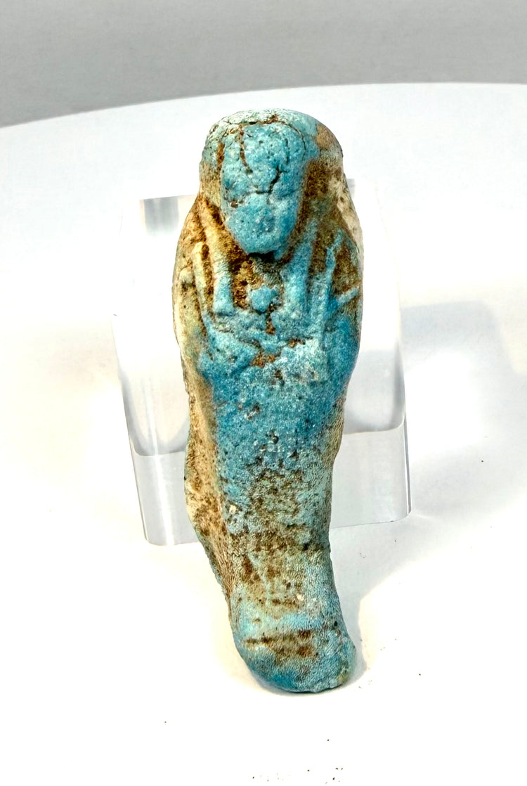 Ancient Egyptian shabti figure from the Late Period–Ptolemaic era, displaying vibrant turquoise glaze, crossed arms, and a rounded head.