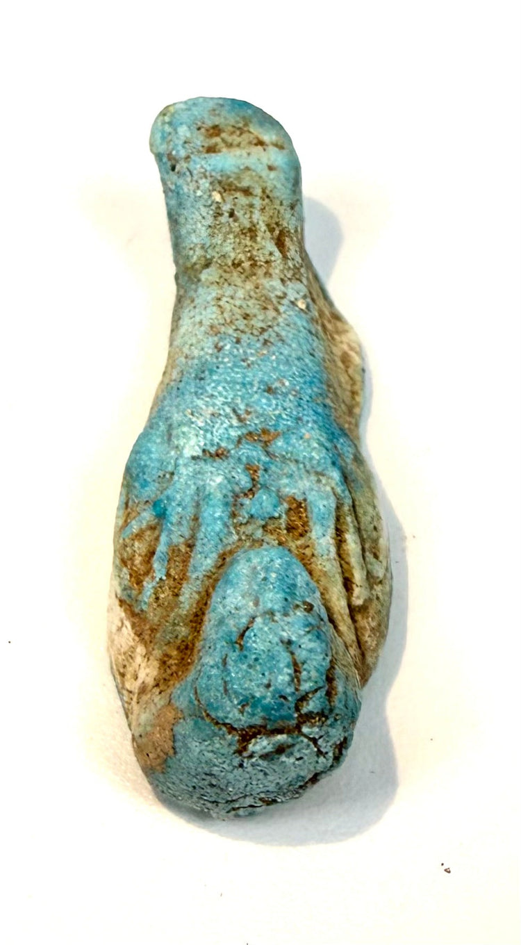 Ancient Egyptian shabti with a traditional mummiform silhouette, surviving turquoise glaze, and an elongated lower section with a curved base.