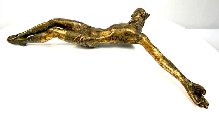 Detailed facial features of bronze Jesus Christ sculpture, showing lowered eyes, sculpted hair, and beard.