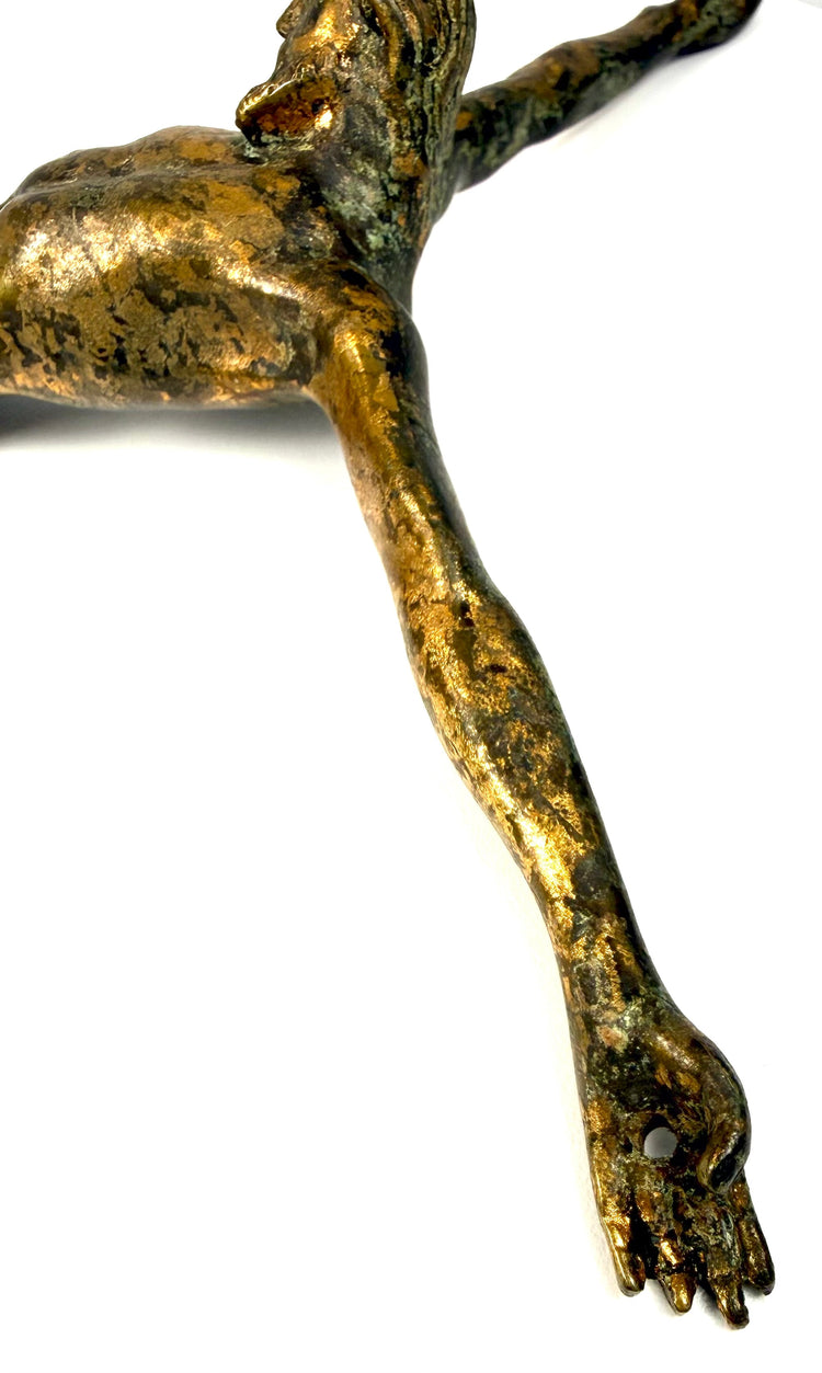 Antique European crucified Christ sculpture preserved without its original cross, featuring extended arms and crossed feet.