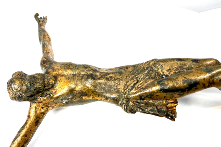 Crossed feet of European bronze crucified Christ figure with surviving gilding and centuries-old surface wear.
