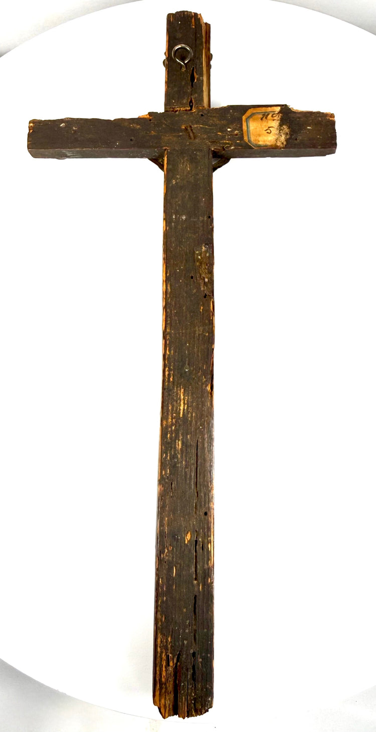 Dark-painted pine wood of an antique French peddler’s cross showing historic surface wear, exposed wood grain, and aged patina.
