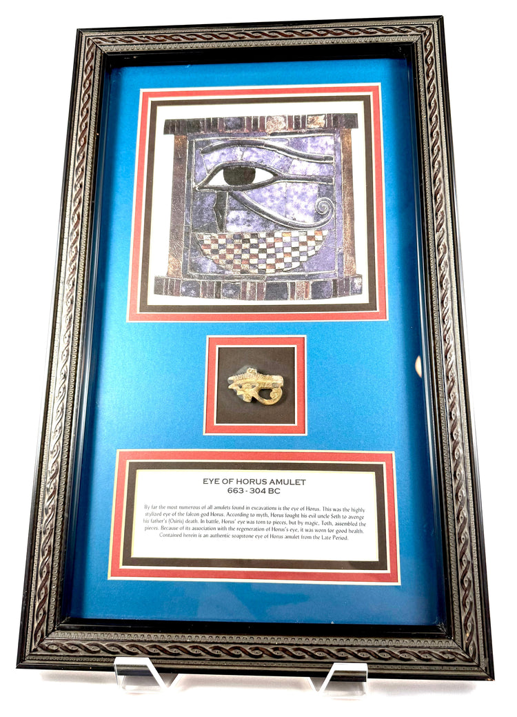 Decorative framed Egyptian antiquity featuring an ancient Eye of Horus amulet beneath a colourful illustration of the Wedjat symbol.