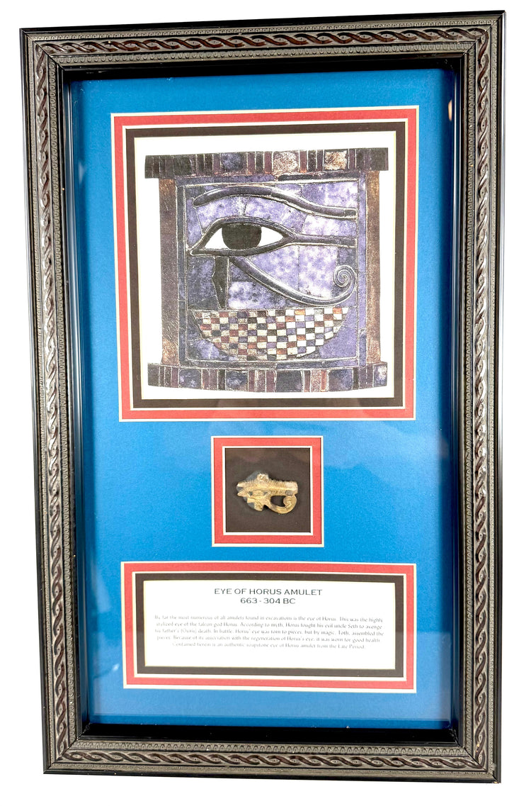 Ornate black wooden frame with burgundy and gold-coloured matting surrounding an ancient Egyptian protective amulet and historical artwork.