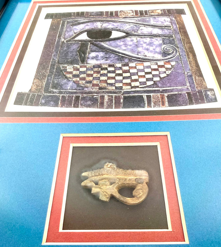 Ancient Egyptian carved stone Eye of Horus amulet with distinctive eyebrow, curved markings, and openwork detailing.