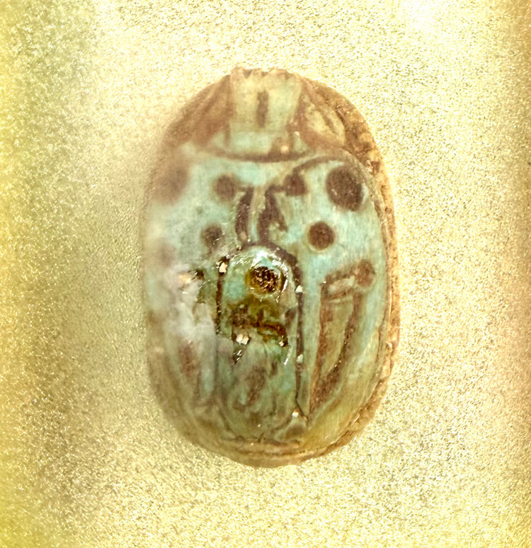 Ancient Egyptian scarab beetle with surviving turquoise glaze, brown discolouration, and carved markings associated with Khepri.