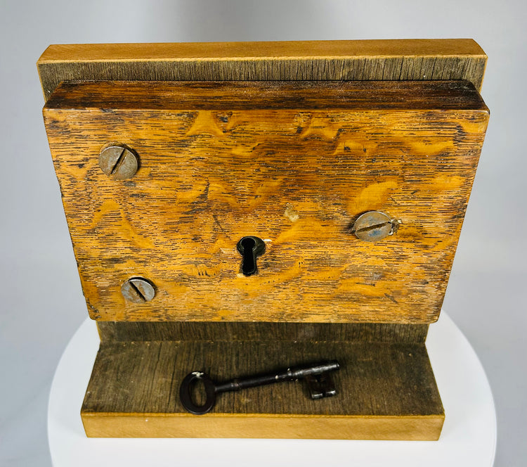 Antique wood and iron lock mechanism mounted for display with original key