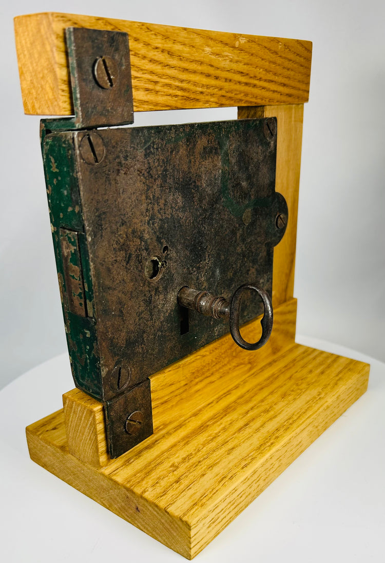 Mounted vintage lock mechanism with key illustrating early security design