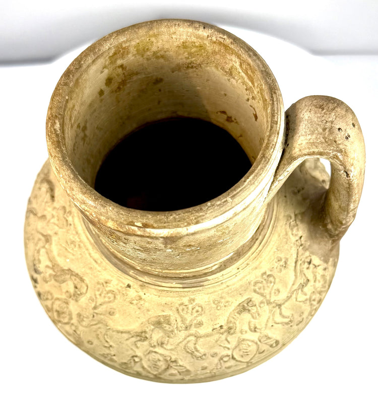 Antique Persian Seljuk-style ewer with horizontal decorative bands separating raised animal imagery from lower geometric ornamentation.