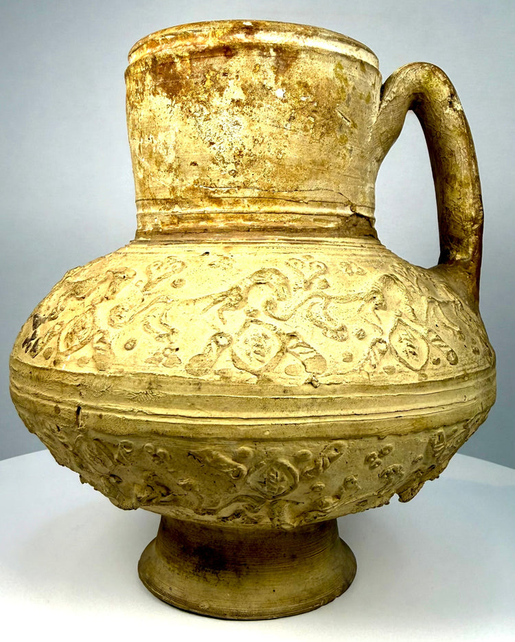 Medieval Persian pottery ewer displaying stylized quadruped figures, circular medallions, and decorative foliate patterns.