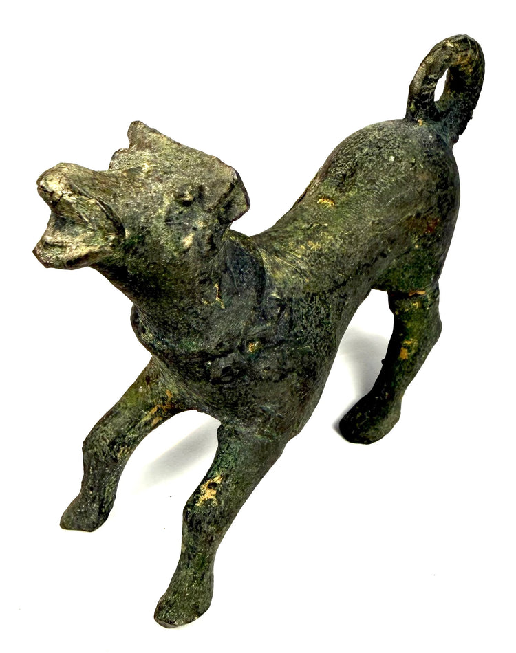 Roman bronze canine sculpture with raised head, extended forelegs, decorative collar, and dark green surface patina.