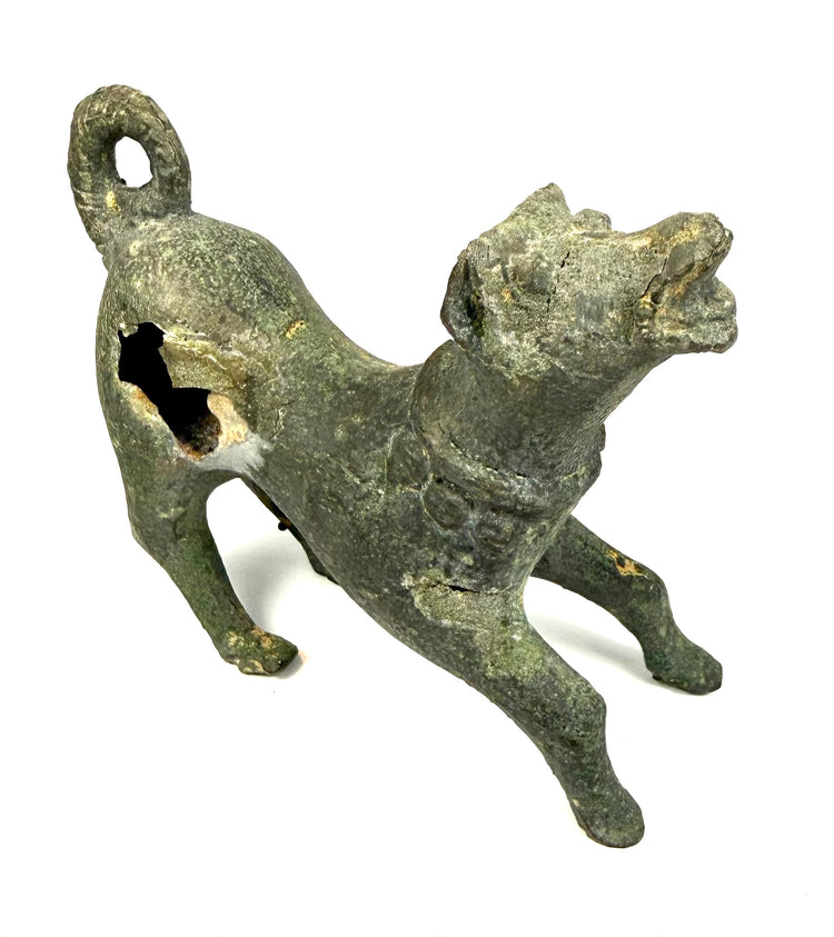 Roman-period cast bronze canine figurine displaying olive-green, grey-green, and brown patination with surface oxidation.