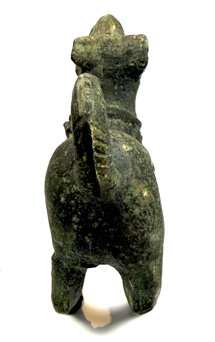 Close-up of the tightly curled and pierced tail on an ancient Roman bronze barking dog statuette.
