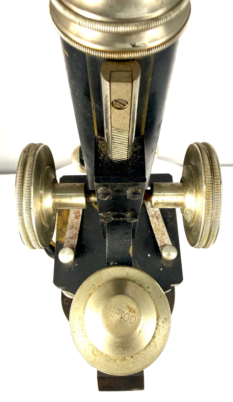 Close-up of a vintage Spencer microscope featuring its nickel-plated focusing wheels, black optical tube, and precision adjustment mechanisms.