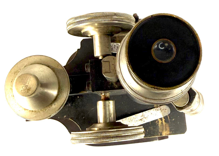 Overhead close-up of an antique Spencer microscope showing the circular eyepiece opening, nickel-plated adjustment wheels, and optical fittings.