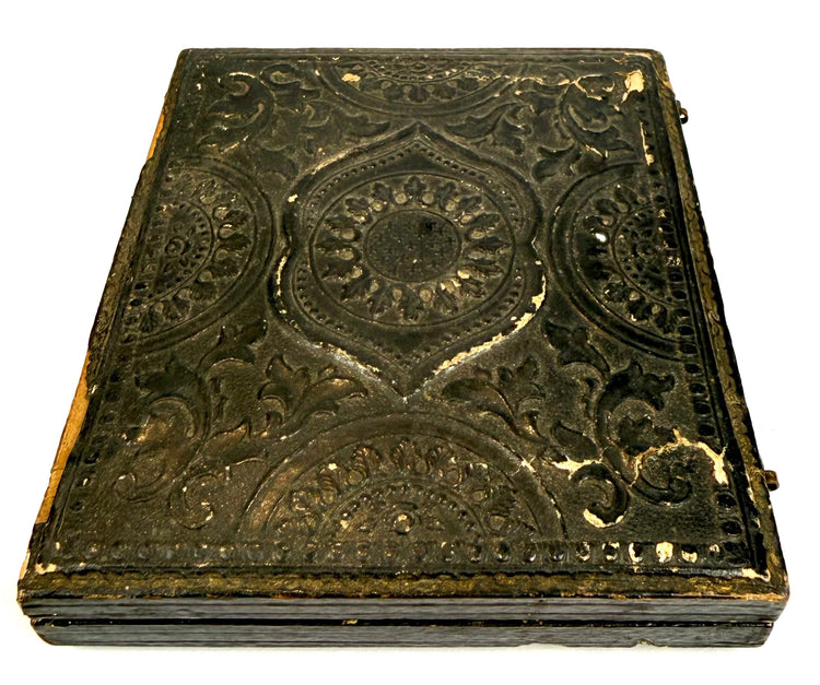 Antique Victorian portrait case with intricate ornamental embossing, geometric detailing, and aged dark exterior finish.