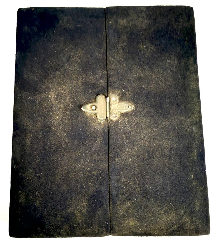 Antique folding photographic keepsake case featuring a dark velvet exterior, aged fabric texture, and three-panel construction.