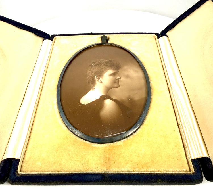 Victorian folding portrait case featuring a removable oval metal photograph frame, protective glazing, and elegant textile lining.