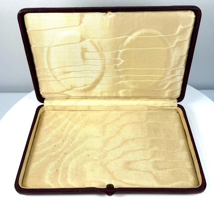 Empty open antique portrait presentation case showing its cream-coloured patterned lining and fitted compartment with the portrait panel removed.