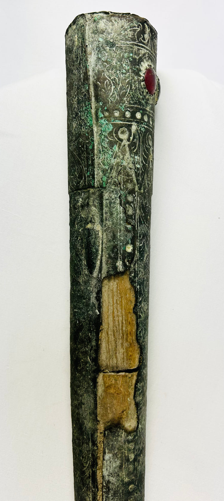 Vertical view of upper Etruscan bronze sword sheath with intricate carvings, gemstone inlay, and bronze patina – early Iron Age artifact