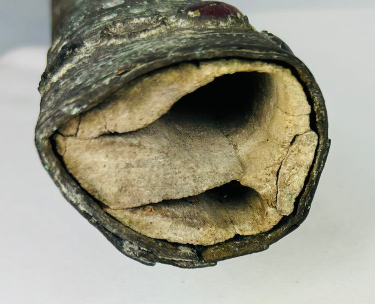 Detail of the pointed end of an Etruscan bronze sword sheath with deep green patina and ancient surface wear – authentic early Etruscan artifact