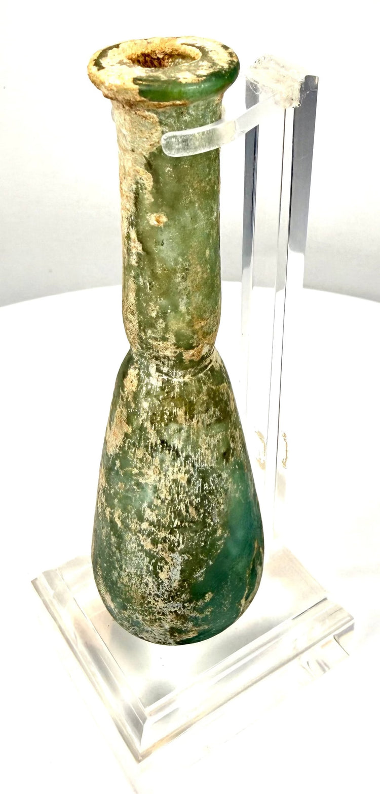 Roman glass perfume vessel with a rounded pear-shaped body, narrow opening, and distinctive elongated neck.