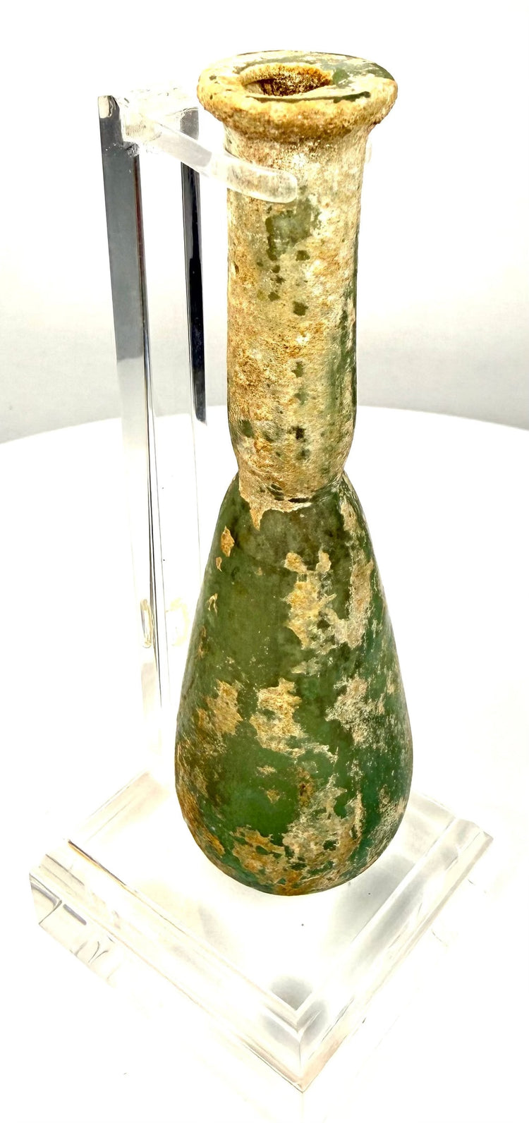Ancient Roman olive-green glass unguentarium featuring extensive mineral deposits concentrated around the neck and rim.