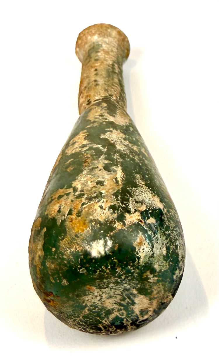 Ancient Roman green glass perfume bottle, circa 1st–4th century CE, displaying extensive surface weathering and mineral encrustation.