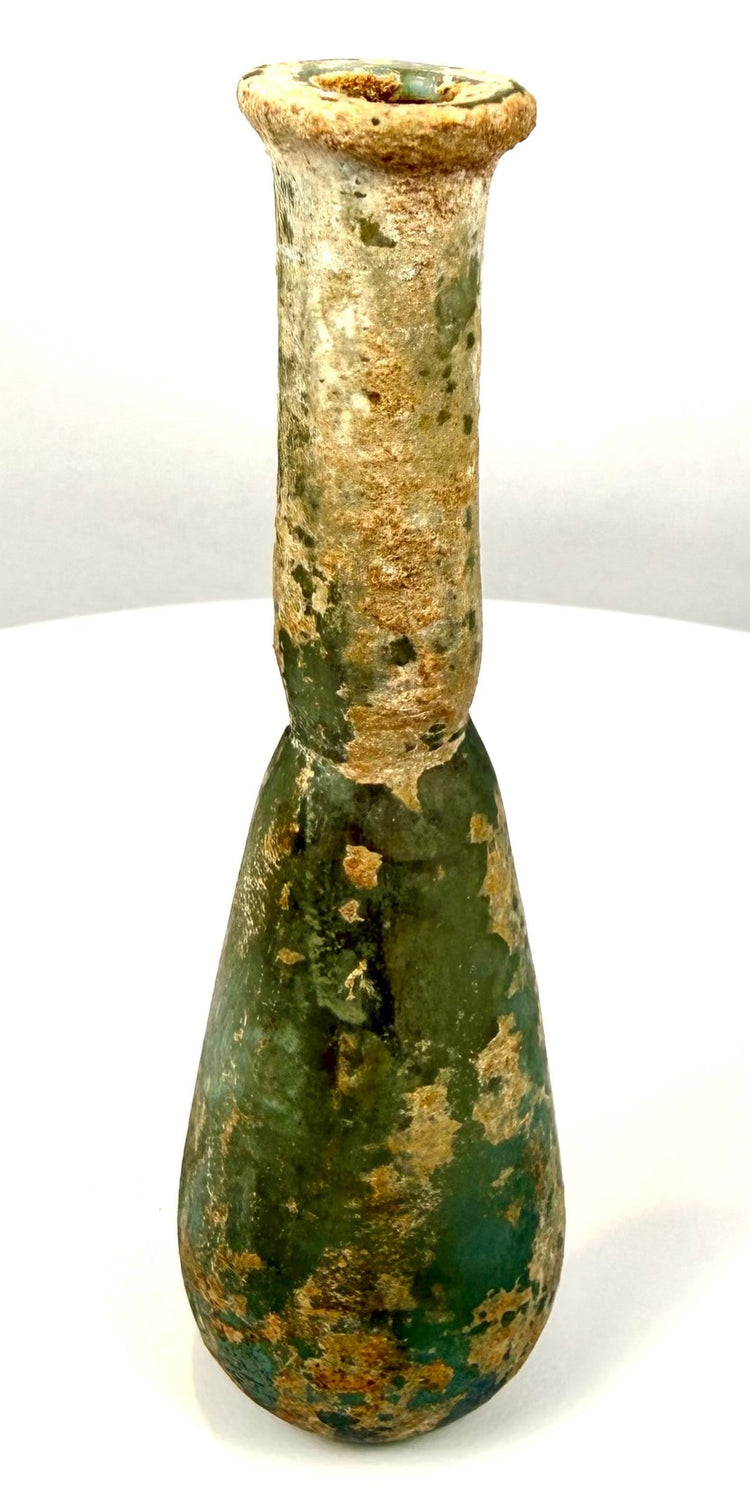Roman green glass unguentarium with a gracefully tapering shoulder, cylindrical neck, and rounded lower body.