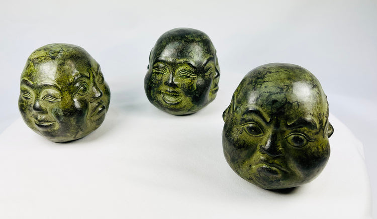 20th century Himalayan cast metal Buddha heads, sand-filled, patinated bronze finish, set of three in traditional brocade box, devotional and ritual meditation objects