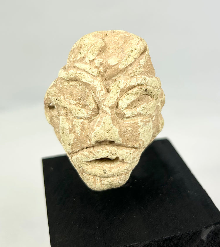 Mesopotamian stone sculpture head from votive figure, broad nose and simplified eyes, mounted for display