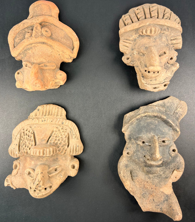 Black-framed display of Pre-Columbian terracotta mask fragments, varied expressions