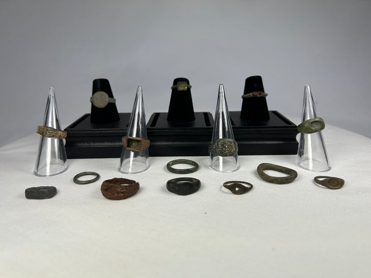 Set of ancient bronze rings with varied designs, patinas, and historic origins