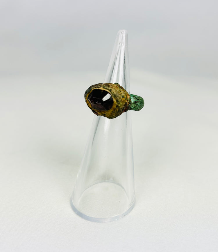 Neo-Assyrian bronze ring featuring red garnet gemstone and aged patina