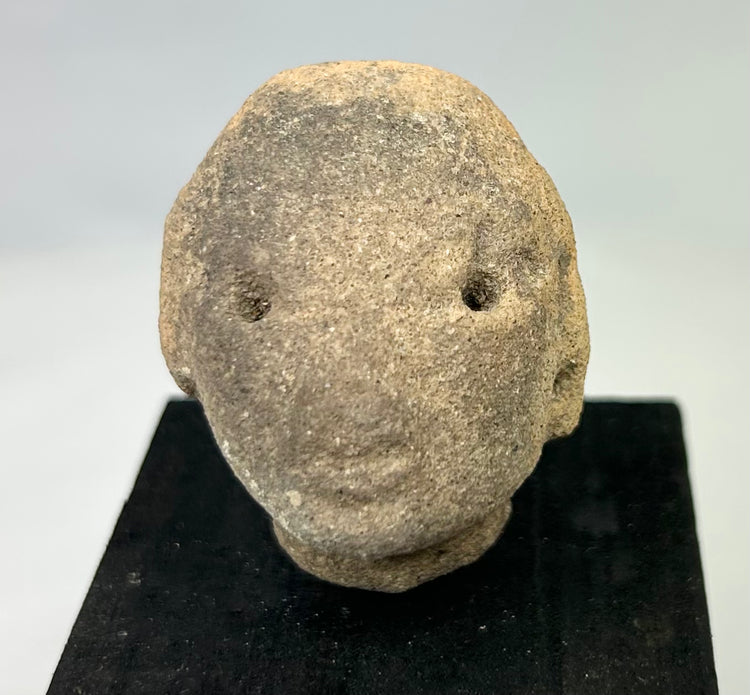 Small Pre-Columbian terracotta head from Nayarit or Jalisco, mounted, with rounded features and drilled eyes, 300 BCE–300 CE
