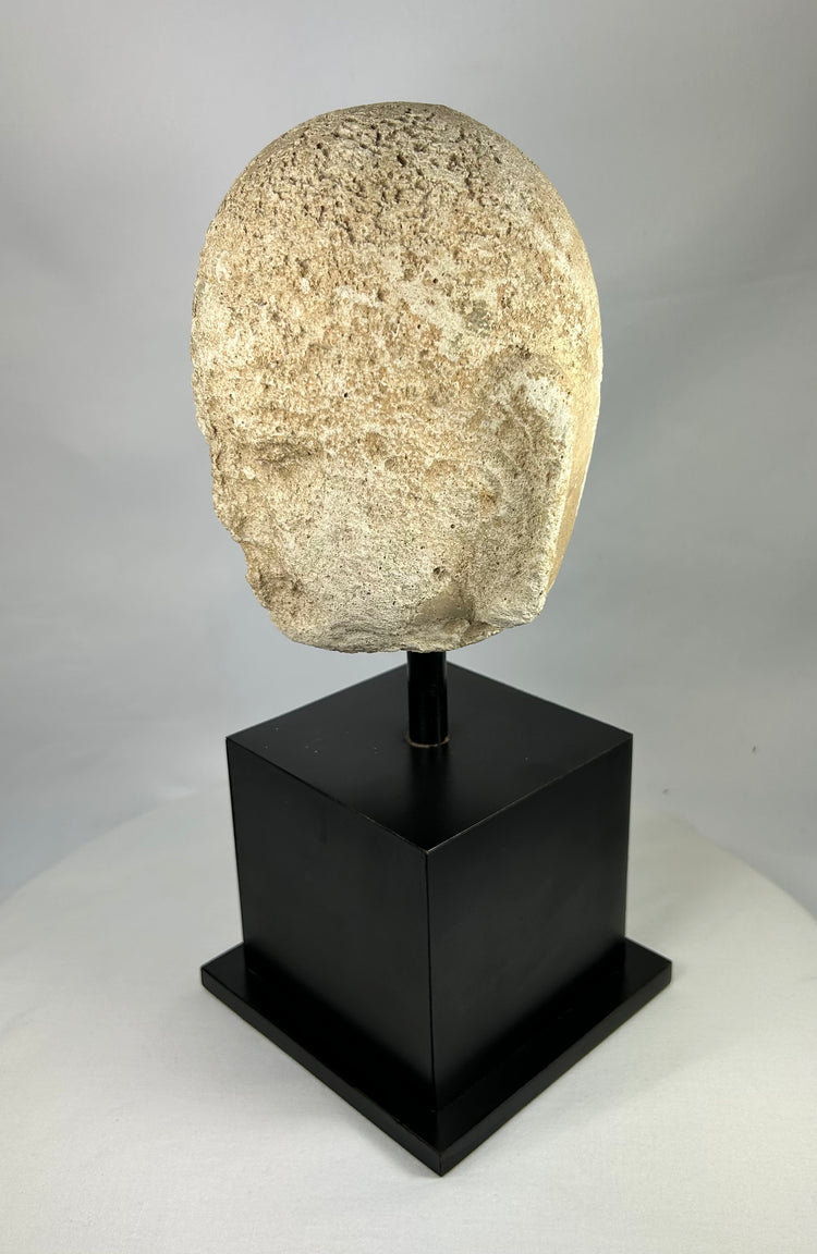 Close-up of 13th–14th century Southeast Asian carved Buddha head, showing detailed curls and gentle facial expression, stone sculpture from Burma or Thailand.