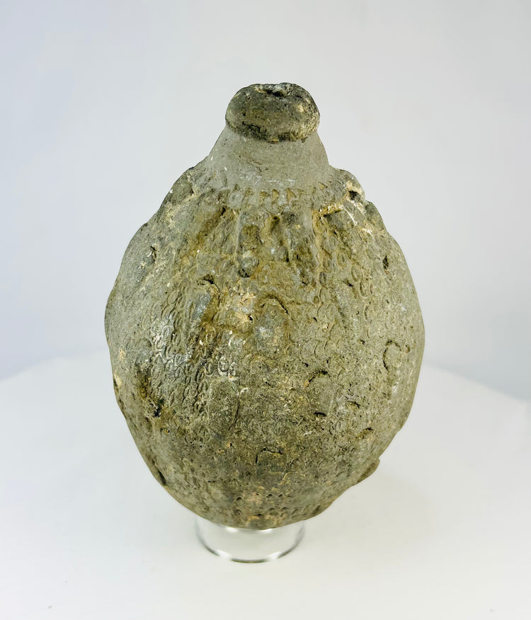 Front view of an Islamic ceramic hand grenade from Greater Persia, 10th–12th century CE, showing its textured surface, conical neck, and aged earthen patina on a white background.