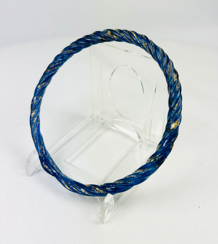 Angled left view of Roman glass bracelet highlighting twisted pattern and deep cobalt-blue coloration.
