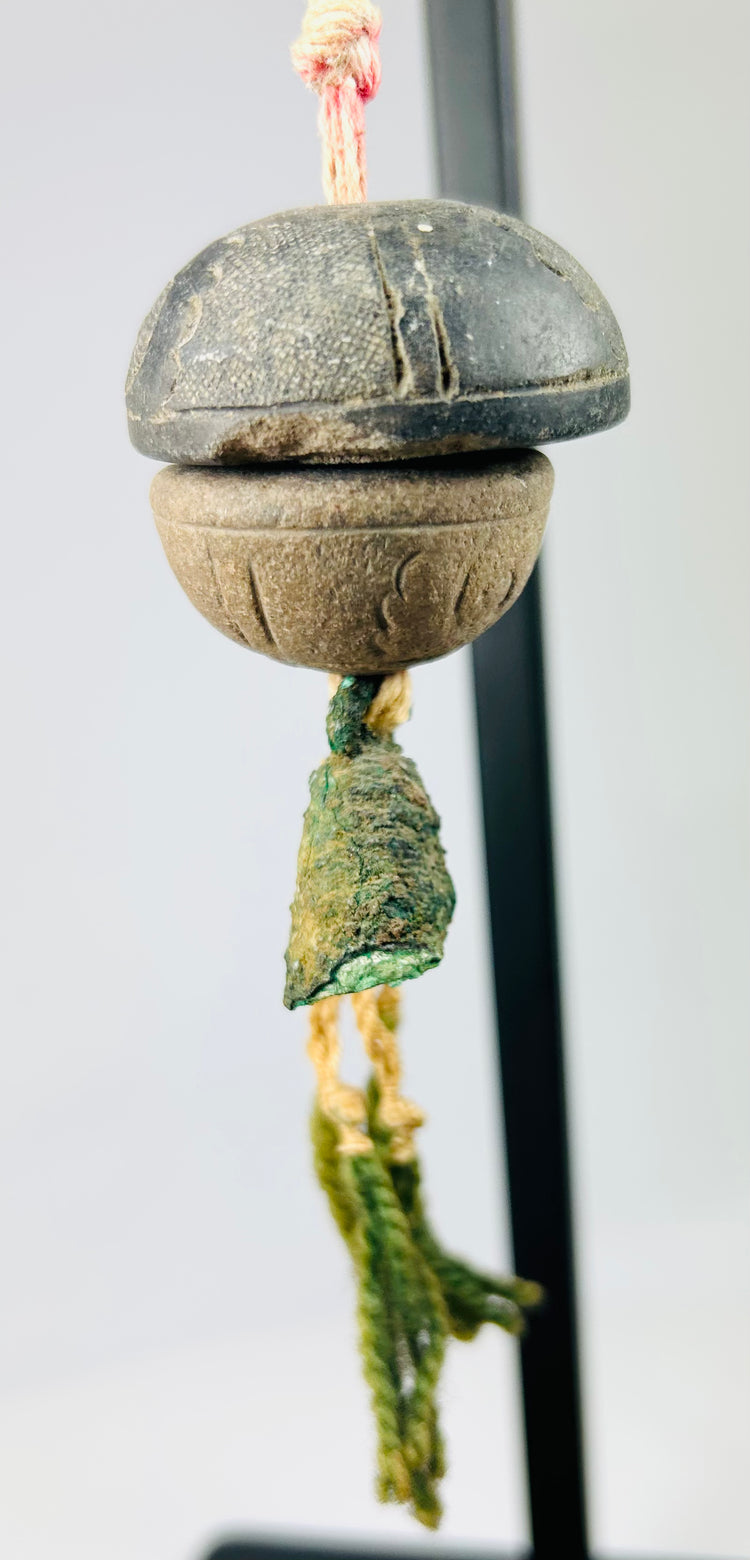 Side profile of bronze ritual bell showing smooth curvature and patinated surface details