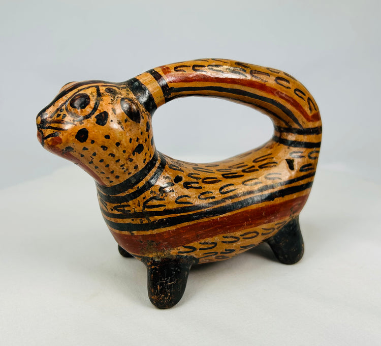 Side profile of polychrome feline effigy vessel with arch handle and ochre-black slip pattern, circa 800–1200 A
