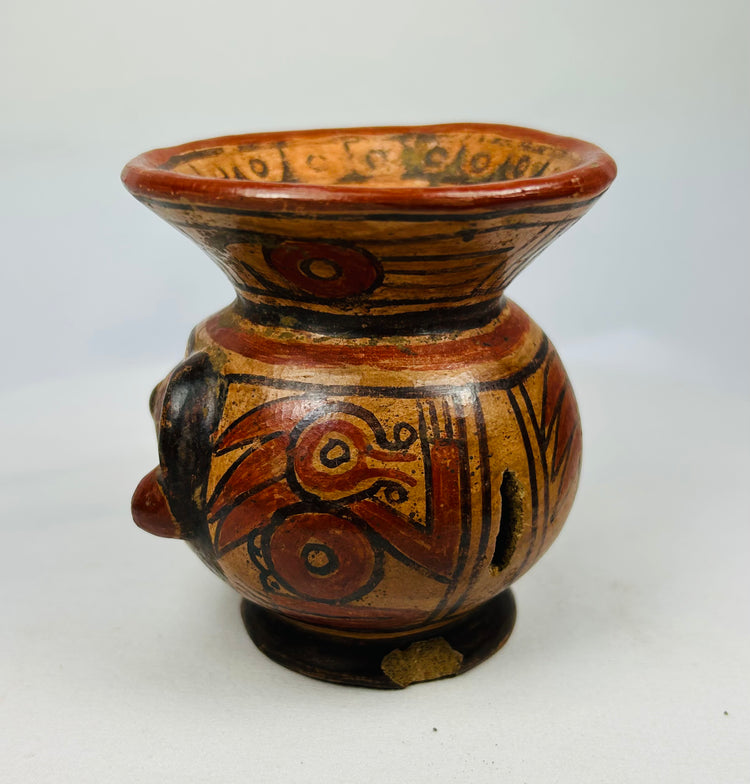 Left side of Guanacaste-Nicoya human-head effigy bowl showing painted cheek and decorative rim band