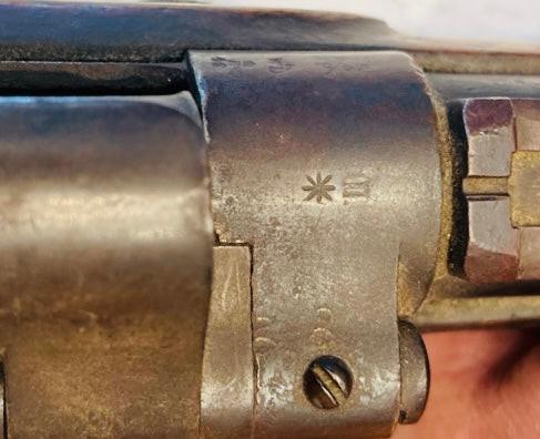 Close-up of engraved proof marks on the metal receiver of a Victorian-era Enfield Snider Conversion rifle.