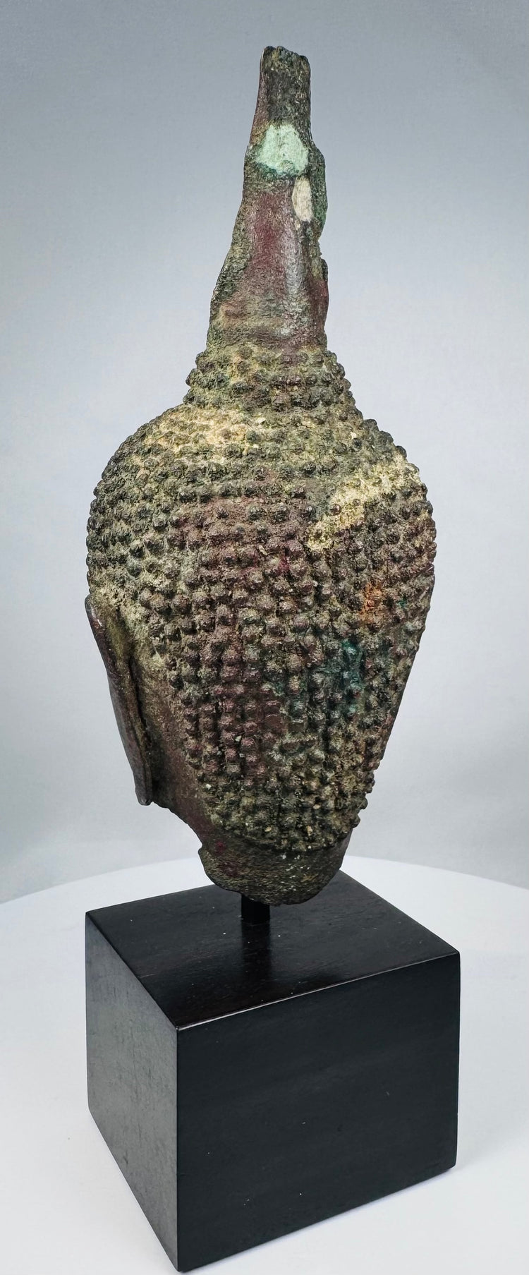 Fourteenth-century Thai Buddha head with almond-shaped eyes and arched brows