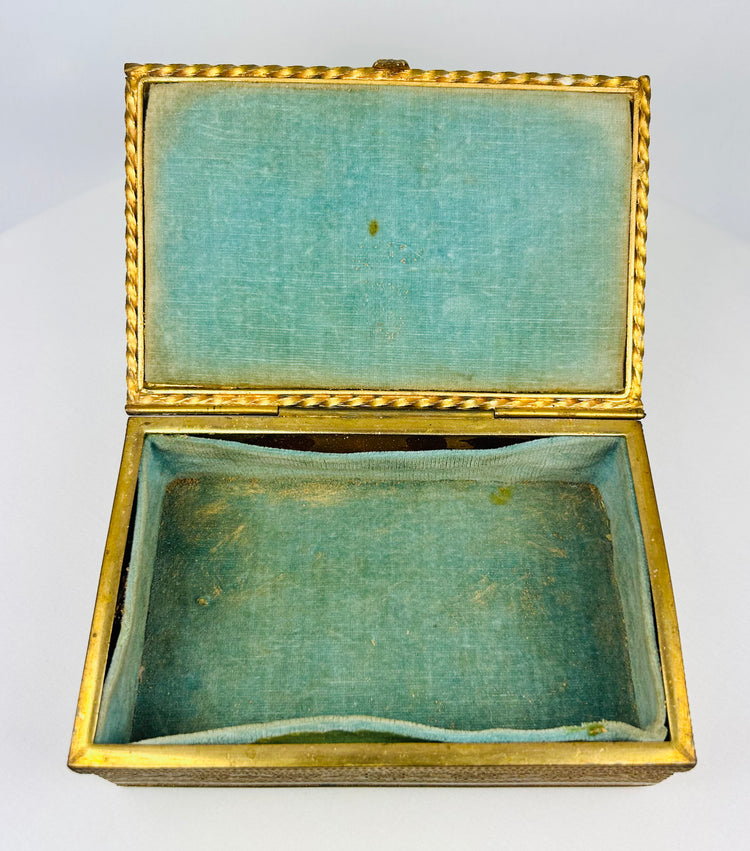 Close-up of the portrait miniature on the lid of an antique gold jewelry box.