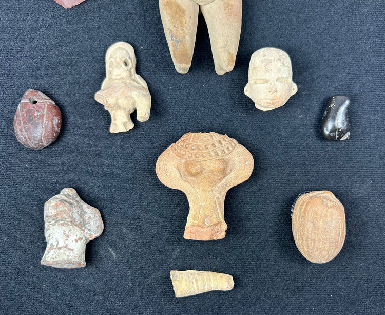 Archaeological terracotta figurines and stone relics from ancient Mesoamerica displayed together.