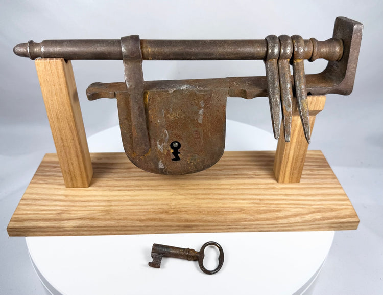 Historic wrought-iron gate lock showing its long security bar and shaped end finial