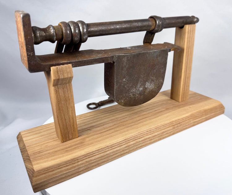 Historic sliding-bar gate lock showing the hinged hasp and internal locking components