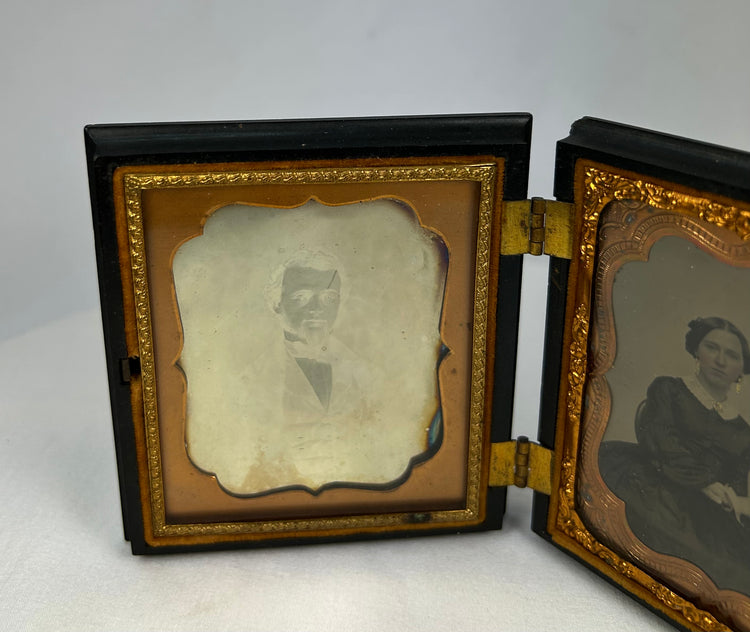 Open 19th-century photo case displaying paired daguerreotype portraits