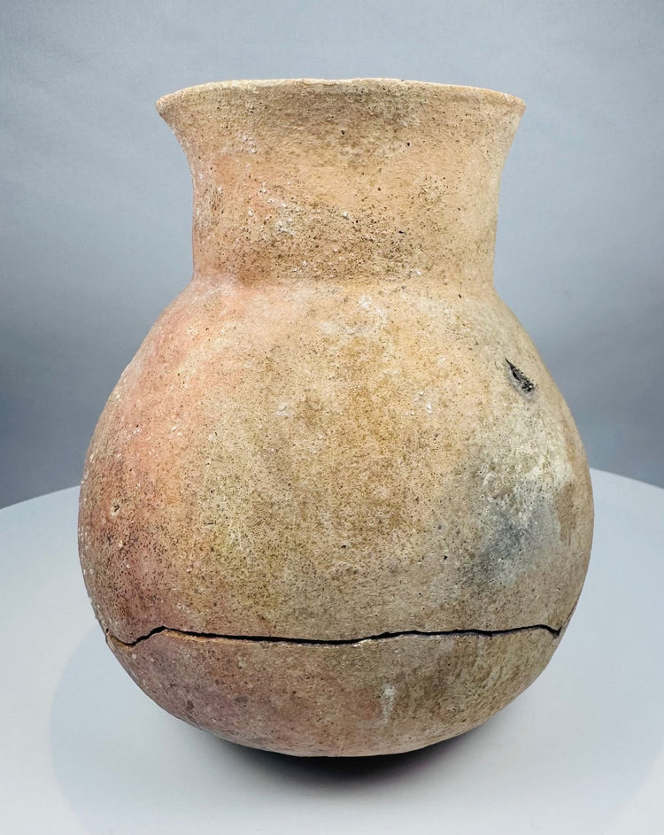 Ancient Central American ceramic storage vessel in natural buff and reddish clay tones