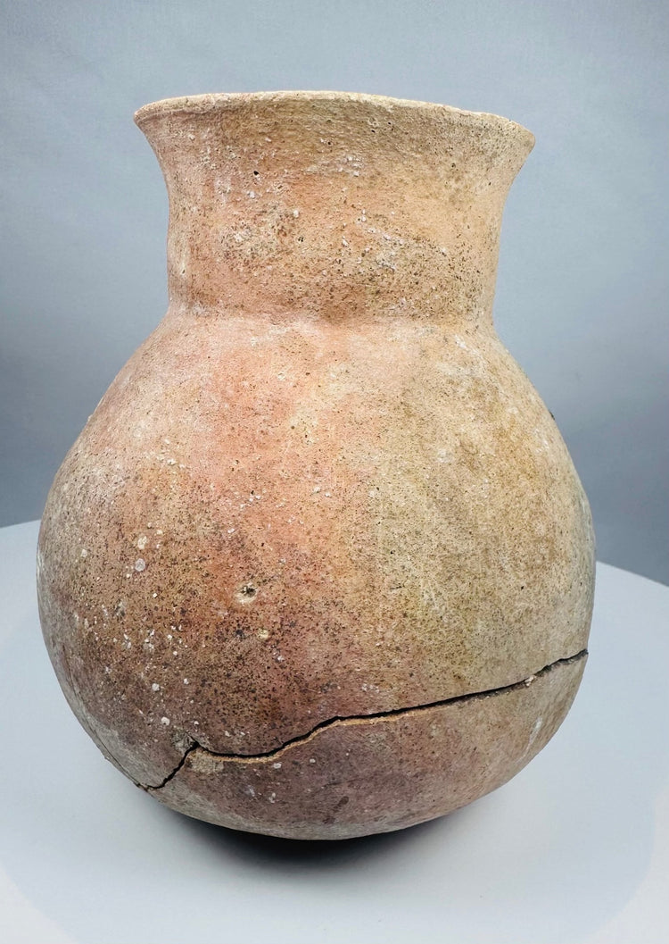 Side angle of an ancient globular pottery vessel with a constricted shoulder and tall neck